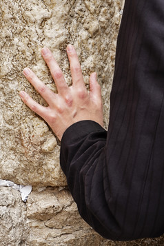 手触摸的哀号墙的kotel在祈祷匿名男人。的老城市耶路撒冷