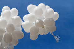 白色气球对的天空群白色气球高飞成的蓝色的天空与光云