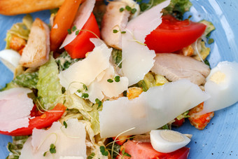 沙拉与鸡和新鲜的蔬菜新鲜的沙拉鸡与蔬菜和奶酪蓝色的背景