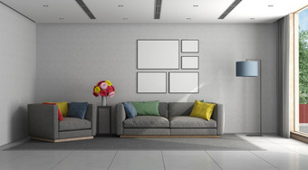 极简主义生活房间与灰色的沙发扶手椅和色彩斑斓的缓冲呈现极简主义生活房间与灰色的沙发和扶手椅