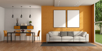 现代生活房间与沙发对橙色墙和餐厅表格与椅子呈现现代生活房间与沙发和餐厅表格