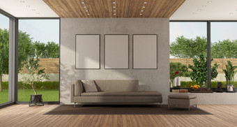 极简主义生活房间与花园背景和现代沙发对混凝土墙呈现现代生活房间与大窗口和沙发