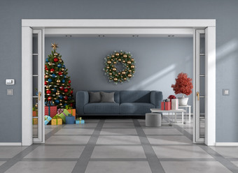 生活房间与滑动通过圣诞节树礼物装饰和蓝色的沙发呈现生活房间与圣诞节树蓝色的沙发和滑动通过