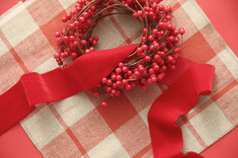 圣诞节花环与红色的浆果而且天鹅绒丝带格子背景