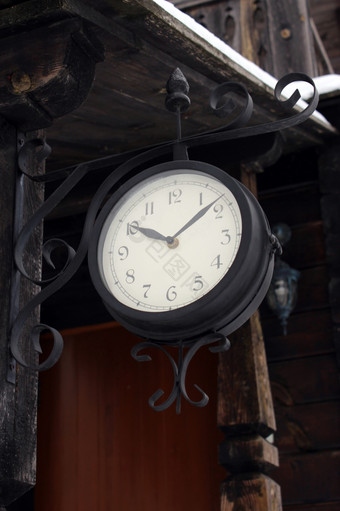 不错的古老的时钟挂附近的木建筑