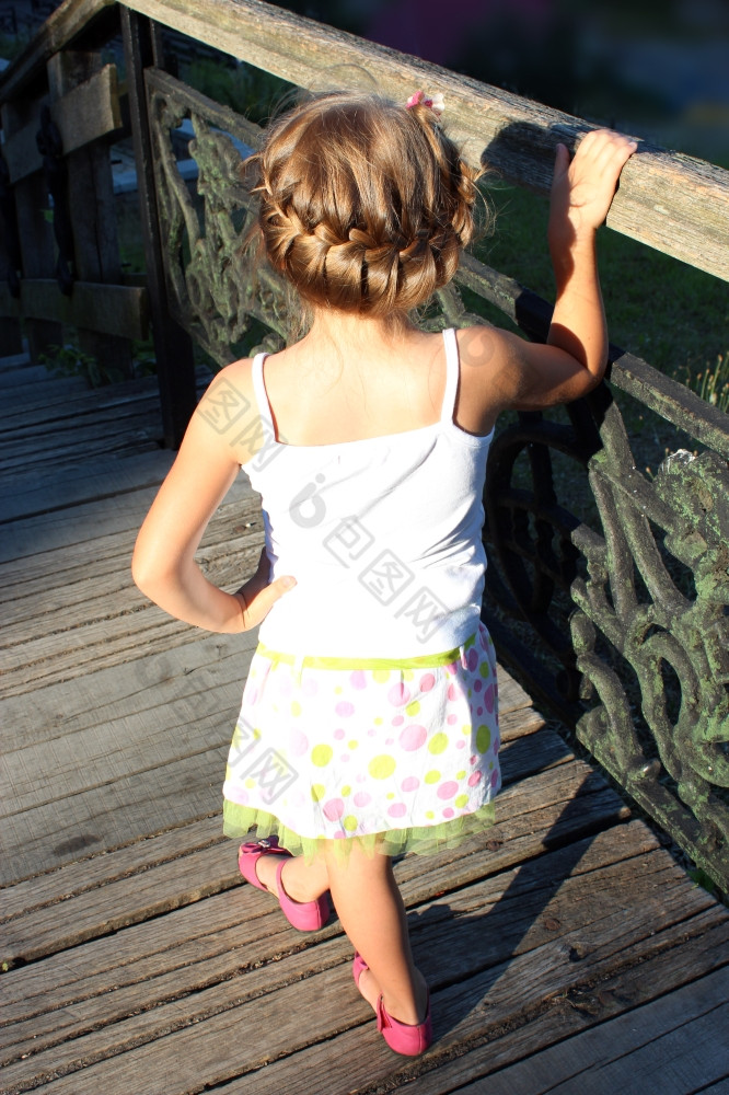 的小女孩与不错的发型站旁边栏杆