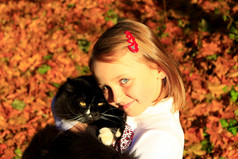 女孩拥抱与她的猫秋天小女孩拥抱与她的黑色的猫秋天