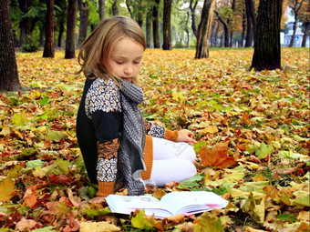 年轻的女孩读取书的秋天公园年轻的女孩读取书的秋天公园年轻的女孩读取书的秋天公园说谎的地面