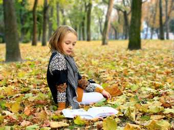 年轻的女孩读取书的秋天公园年轻的女孩读取书的秋天公园年轻的女孩读取书的秋天公园说谎的地面
