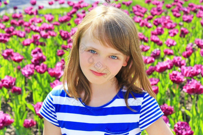 肖像美丽的年轻的女孩淡紫色郁金香背景肖像美丽的年轻的女孩的淡紫色郁金香背景
