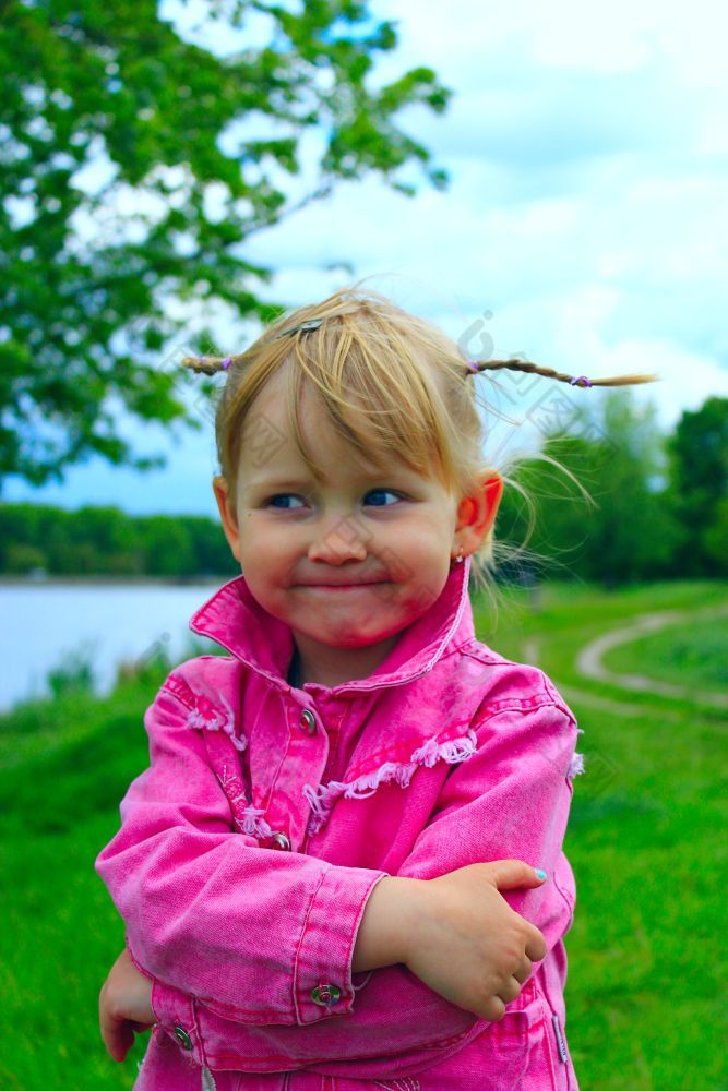漂亮的微笑婴儿女孩与不错的辫子漂亮的时尚微笑婴儿女孩与不错的辫子附近的河