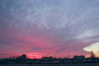 红色的日落以上多层房子晚上城市景观城市景观黄昏小镇《暮光之城》与朱砂日落大粉红色的云以上晚上城市红色的日落以上多层房子大粉红色的云以上晚上城市