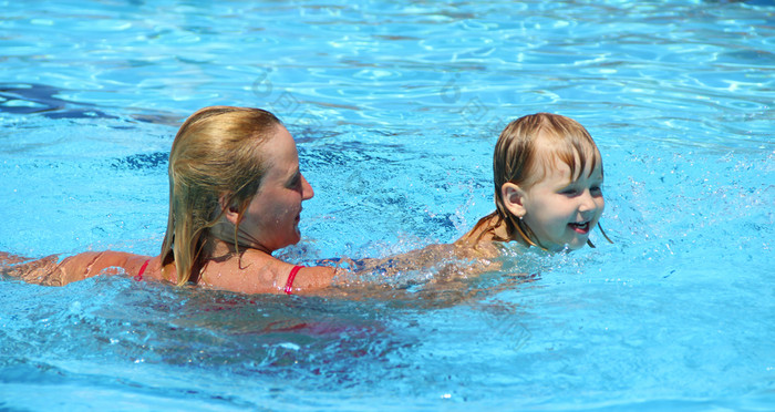快乐妈妈。游泳与她的女儿游泳池快乐家庭休息度假胜地家庭享受夏天假期人享受假期蓝色的水游泳池快乐妈妈。游泳与她的女儿游泳池