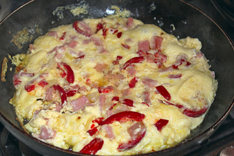 烹饪煎蛋卷与红色的红辣椒和香肠美味的食物烹饪锅烹饪煎蛋卷与红色的红辣椒美味的食物