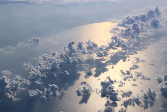美丽的视图从窗口飞机飞行在云和海表面自然全景与云白色云移动以上水表面海景观与太阳反映了海表面美丽的视图从窗口飞机飞行在云和海表面