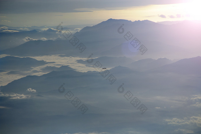 美丽的视图从窗口飞机视图从飞机窗口另一个飞机飞行在云和山阳光明媚的射线全景与飞行飞机高天空以上山脊和云视图从飞机窗口另一个飞机飞行在云和山