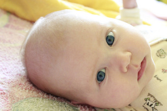 肖像微笑婴儿与蓝色的眼睛新生儿孩子看妈妈。脸新生儿婴儿关闭肖像微笑婴儿与蓝色的眼睛新生儿孩子看妈妈。