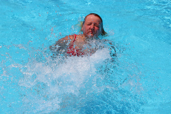 运动型概念快乐女孩年轻的女人享受夏天假期sportwoman游泳池女孩潜水成透明的水池运动型概念快乐女孩年轻的女人享受夏天假期