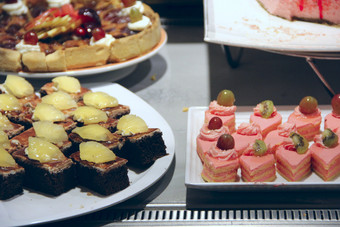 不同的蛋糕与块水果吃蛋糕装饰菠萝猕猴桃和葡萄集蛋糕餐厅享受甜蜜的菜餐厅丰富的选择新鲜的甜点吃蛋糕装饰菠萝猕猴桃和葡萄丰富的选择甜点