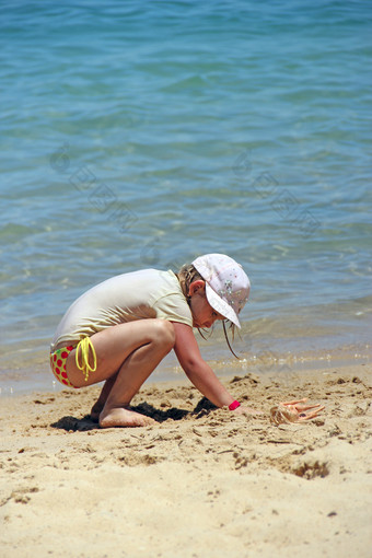 小女孩玩与沙子海滩女孩玩沙子附近海在夏天假期夏天假期概念女孩玩沙子附近海在夏天假期夏天假期概念