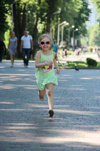 快乐孩子运行城市公园积极的幼稚的emitions孩子运行沿着路径微笑和欢乐快乐童年小女孩享受运行快乐孩子运行城市公园小女孩享受运行