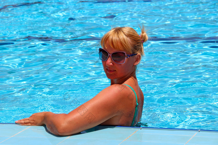 有吸引力的女人摆姿势在放松游泳池在假期年轻的女人太阳镜享受夏天假期夏天假期热带度假胜地女人休息游泳池有吸引力的女人摆姿势在放松游泳池在假期