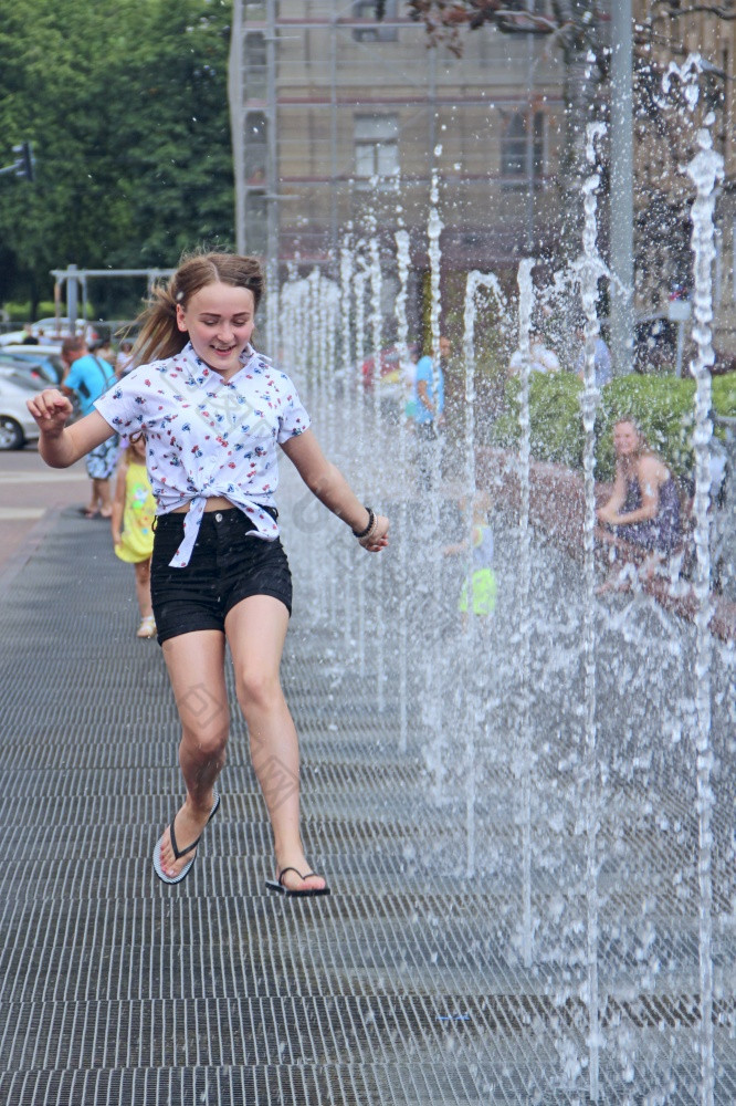 小女孩有有趣的喷泉热夏天天气城市小女孩冷却喷泉热天气小女孩有有趣的喷泉热夏天天气城市