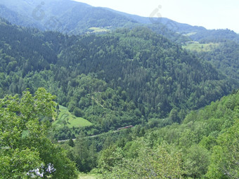 乘客火车骑在山山景观铁路运输山景观与山覆盖与绿色森林谷之间的山山全景乘客火车骑在山山景观