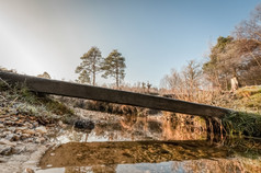 木桥小道穿越在溪在冬天日落