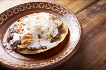 吐司廷加鸡传统的墨西哥自制的鸡祝酒与豆子鸡乳房肉洋葱和辣椒辣椒超过与酸奶油和新鲜的白色奶酪