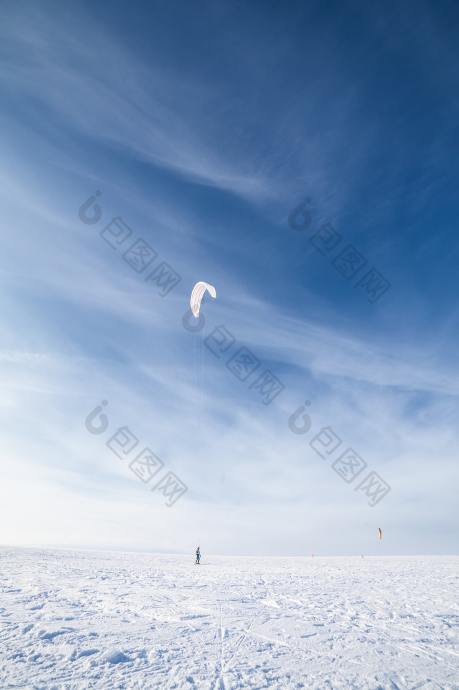 风筝冲浪者被拉他的风筝在的雪风筝冲浪者与蓝色的风筝的雪