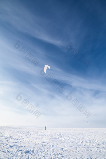 风筝冲浪者被拉他的风筝在的雪风筝冲浪者与蓝色的风筝的雪