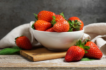 <strong>草莓</strong>概念与集团成熟的红色的<strong>草莓</strong>白色碗关闭额视图古董乡村木表格和灰色背景