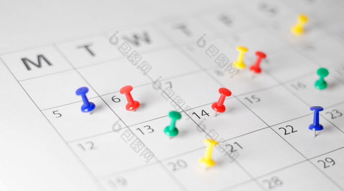 业务日历页面忙调度时间管理最后期限和事件规划概念与许多色彩斑斓的推针每月纸日历页面