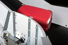 红色的手提箱机场输送机带被运输飞机