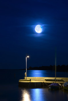 不断上升的月亮在宁静的港码头