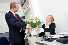 高级经理给他的年轻的女联系大花能与白色雏菊