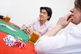 亚洲男人。sittingat的扑克表格在游戏<strong>含糊</strong>不清地微笑的竞争