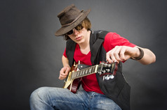 音乐家穿老皮革帽子调优他的吉他