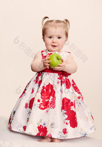 美丽的婴儿女孩与绿色苹果光背景复古的爽肤水