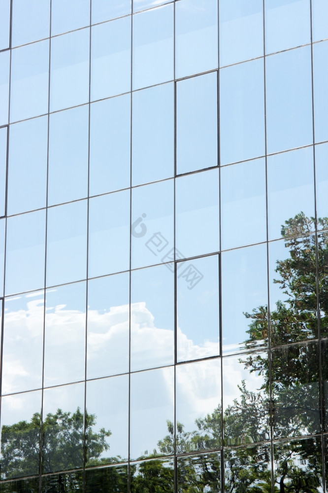 现代建筑玻璃反映了自然树而且云图片