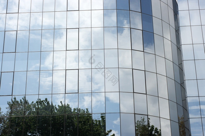 现代建筑玻璃反映了自然树而且云图片