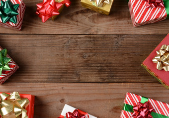 高角视图集团圣诞节礼物乡村木地板上的礼物是分散周围的边缘的框架离开空中间为你的对象复制