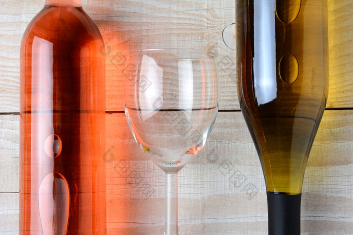 特写镜头酒玻璃之间的瓶红色的酒而且瓶白色酒所有三个对象是铺设乡村白色木表格水平格式从高角