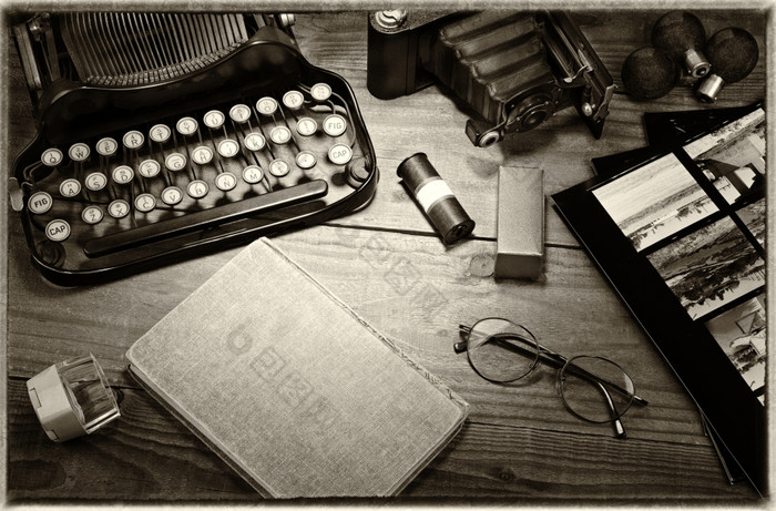 特写镜头古董摄影仍然生活与打字机折叠相机放大镜卷电影闪光灯泡联系打印而且书木表格黑色的而且白色健美的图像为古董感觉