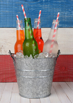 特写镜头桶苏打水瓶与喝吸管对红色的白色而且蓝色的背景为7月野餐