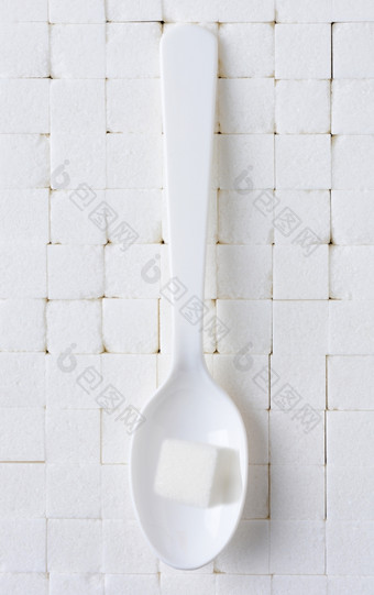 白色塑料勺子与单糖多维数据集背景密切堆放白色糖多维数据集