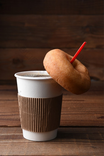 特写镜头纸杯热新鲜的酿造咖啡与红色的勺子平原老成形甜甜圈挂的勺子垂直格式与复制空间