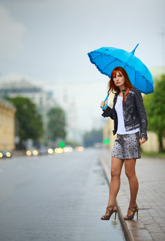 红色头发的人女孩与伞等待公共汽车