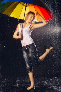 美丽的女孩与伞下雨黑色的背景